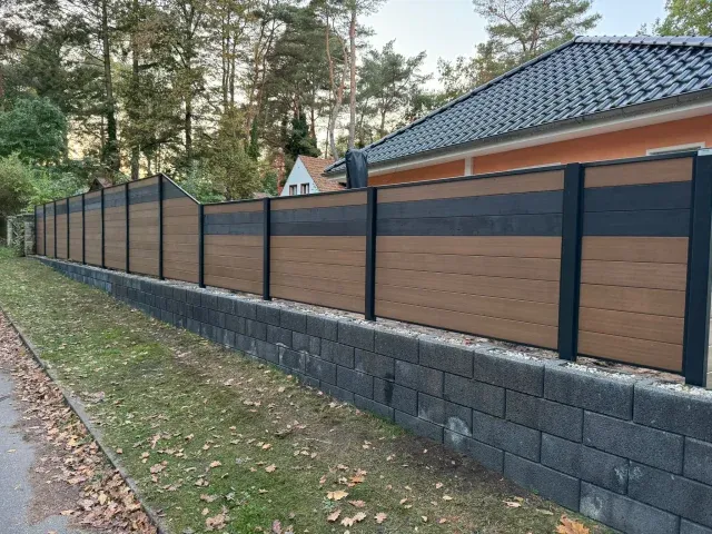 Sichtschutzzaun Berlin über Steinmauer vor Häusern