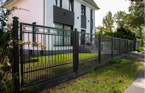 Zaunbau Berlin mit Schmiedezaun vor weißem Haus